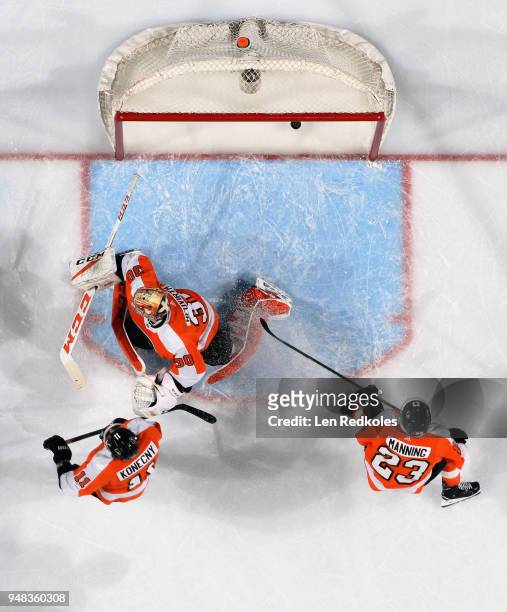 Travis Konecny and Brandon Manning of the Philadelphia Flyers look on as Michal Neuvirth surrenders a third period goal to the Pittsburgh Penguins in...