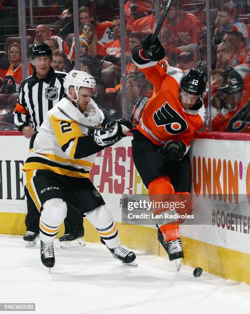 Chad Ruhwedel of the Pittsburgh Penguins checks Michael Raffl of the Philadelphia Flyers into the boards as they pursue the loose puck in Game Four...