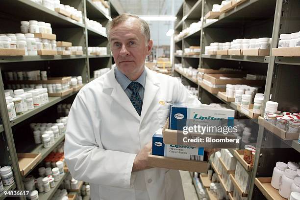 Robert Fraser, chief pharmacist for CanadaDrugs.com, holds boxes containing Pfizer Inc.'s Lipitor heart drug at the company's facility in Winnipeg,...