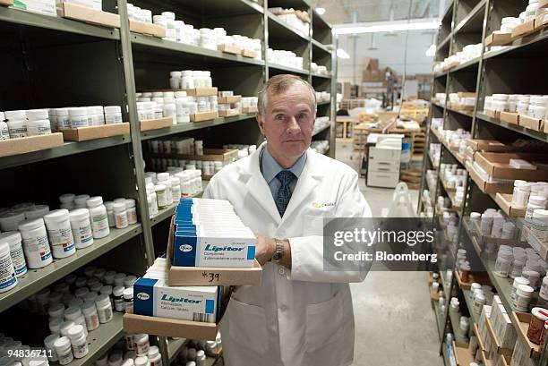 Robert Fraser, chief pharmacist for Canadadrugs.com, holds boxes containing Pfizer Inc.'s Lipitor heart drug at the company's facility in Winnipeg,...