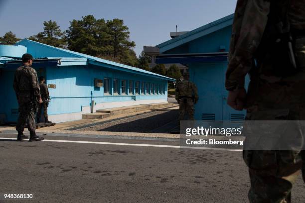 South Korean and U.S. Soldiers stand guard next to the United Nations Command Military Armistice Commission conference buildings at the truce village...