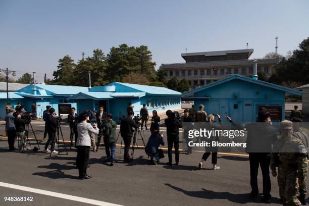 Members of media take photographs and film South Korean and U.S. Soldiers standing guard next to the United Nations Command Military Armistice...