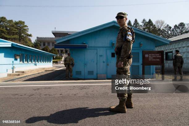 South Korean and U.S. Soldiers stand guard next to the United Nations Command Military Armistice Commission conference buildings at the truce village...