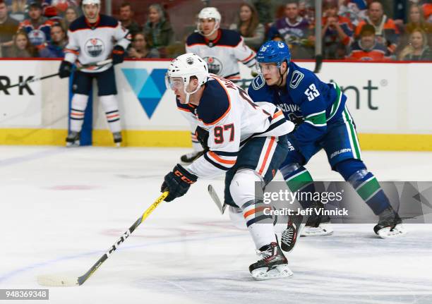 Bo Horvat of the Vancouver Canucks looks on as Connor McDavid of the Edmonton Oilers skates up ice with the puck during their NHL game at Rogers...