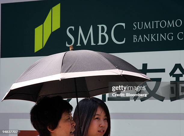 Women walk past a Sumitomo Mitsui Banking Corp. Branch office in Tokyo, Japan, on Wednesday, Sept. 24, 2008. Sumitomo Mitsui Financial Group Inc. May...