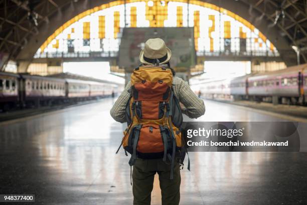 traveler man waits train on railway platform. - 背包客 個照片及圖片檔