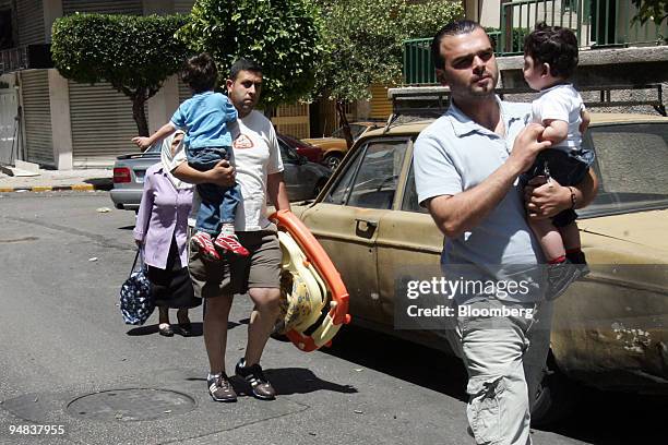 Syrian workers flee an area of the city guarded by the Lebanese army in Beirut, Lebanon, on Friday, May 9, 2008. Gunfights raged across western and...