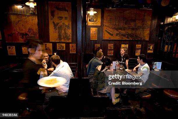 Patrons dine at "Ned Kelly's Last Stand" in Hong Kong, China, on Thursday, May 8, 2008. Munching on a bacon sausage roll, sipping Tsingtao beer and...