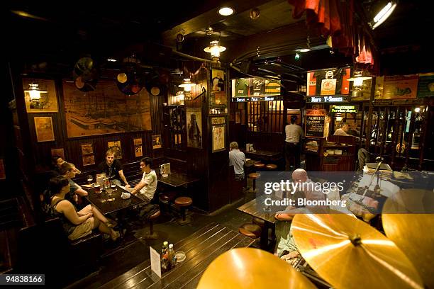 Patrons dine at "Ned Kelly's Last Stand" in Hong Kong, China, on Thursday, May 8, 2008. Munching on a bacon sausage roll, sipping Tsingtao beer and...