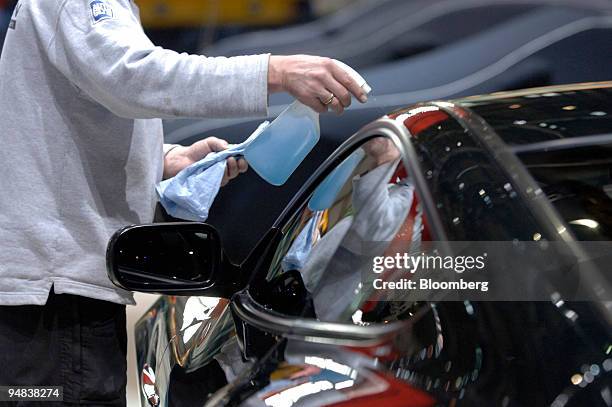 Man cleans an Aston Martin Vanquish S prior to the opening of the Geneva Motor Show in Geneva, Switzerland, Monday, February 27, 2006. The show runs...