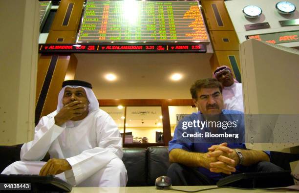 Investors check their stocks while on the floor at the Dubai Financial Market, at the Dubai World Trade Centre, in Dubai, United Arab Emirates, on...