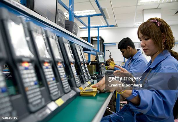 Workers test hand-held inventory computer devices on the assembly line at the Venture Corp. Factory in Singapore, on Monday, Dec. 15, 2008....