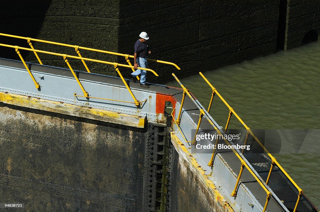 A worker walks along the top of one of Miraflores Locks gate