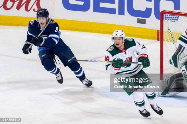 Andrew Copp of the Winnipeg Jets and Jared Spurgeon of the Minnesota Wild follow the play up the ice during second period action in Game Two of the...