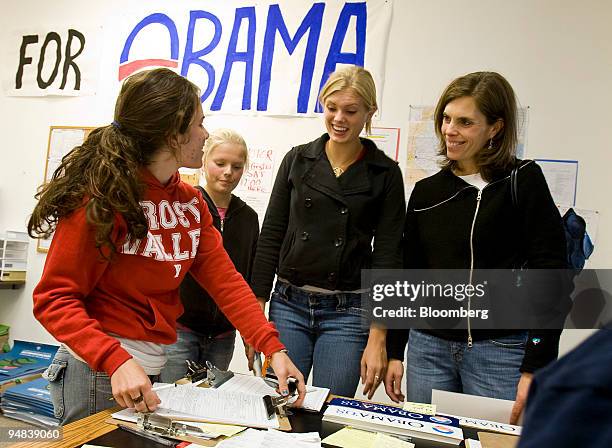 Lexi Cariello, left takes a voter registration form from, Elie Pearson, third from left, of Madison, Wisconsin, after she registered on her 18th...