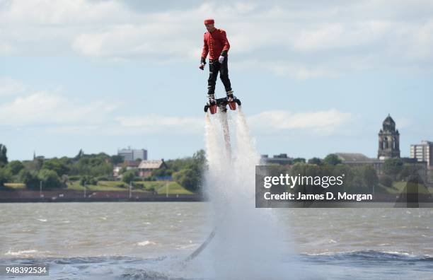 Jay St John flies close to Queen Mary 2 on July 05, 2015 in Liverpool, England. Champion flyboarder Jay St John donned a Cunard Bell Boy's uniform to...