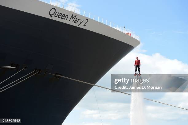 Jay St John flies close to Queen Mary 2 on July 05, 2015 in Liverpool, England. Champion flyboarder Jay St John donned a Cunard Bell Boy's uniform to...