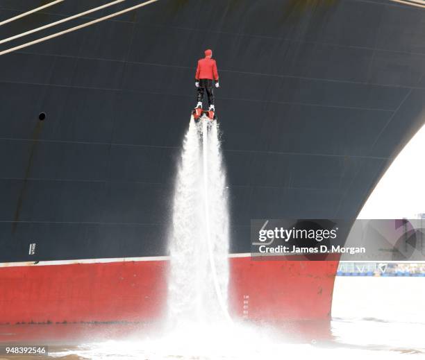 Jay St John flies close to Queen Mary 2 on July 05, 2015 in Liverpool, England. Champion flyboarder Jay St John donned a Cunard Bell Boy's uniform to...