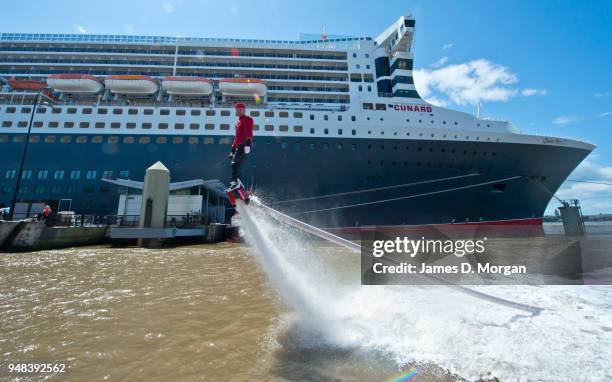 Jay St John flies close to Queen Mary 2 on July 05, 2015 in Liverpool, England. Champion flyboarder Jay St John donned a Cunard Bell Boy's uniform to...