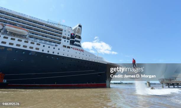 Jay St John flies close to Queen Mary 2 on July 05, 2015 in Liverpool, England. Champion flyboarder Jay St John donned a Cunard Bell Boy's uniform to...