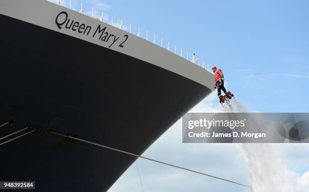 Jay St John flies close to Queen Mary 2 on July 05, 2015 in Liverpool, England. Champion flyboarder Jay St John donned a Cunard Bell Boy's uniform to...