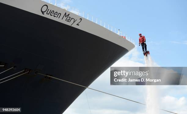 Jay St John flies close to Queen Mary 2 on July 05, 2015 in Liverpool, England. Champion flyboarder Jay St John donned a Cunard Bell Boy's uniform to...