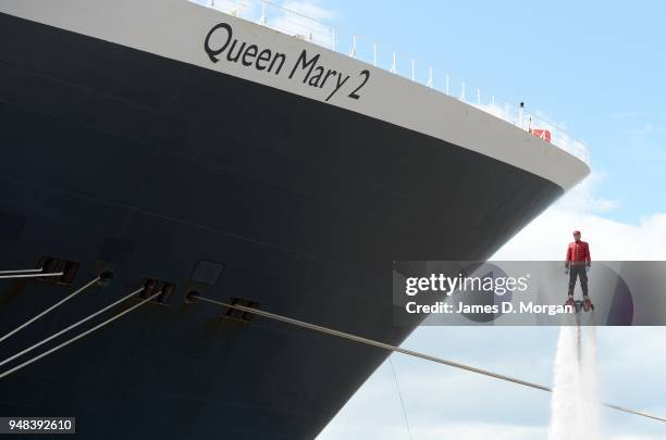 Jay St John flies close to Queen Mary 2 on July 05, 2015 in Liverpool, England. Champion flyboarder Jay St John donned a Cunard Bell Boy's uniform to...