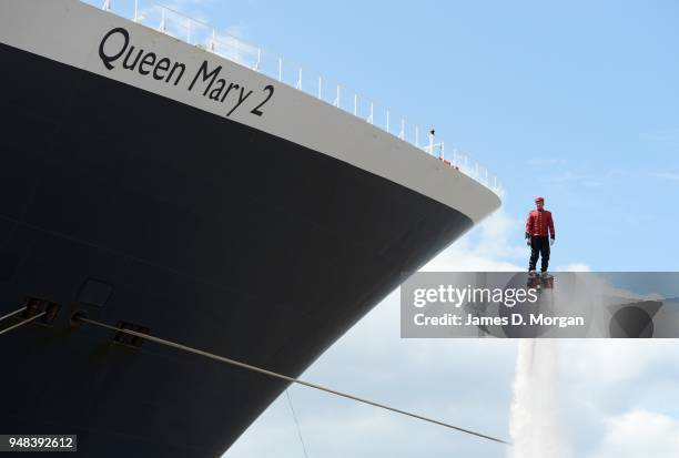 Jay St John flies close to Queen Mary 2 on July 05, 2015 in Liverpool, England. Champion flyboarder Jay St John donned a Cunard Bell Boy's uniform to...