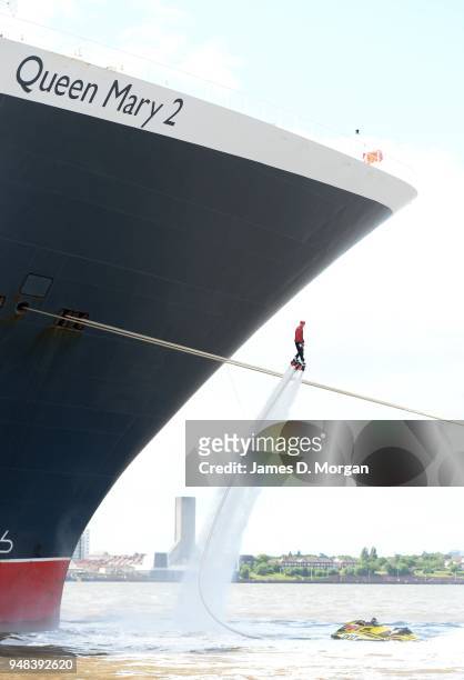 Jay St John flies close to Queen Mary 2 on July 05, 2015 in Liverpool, England. Champion flyboarder Jay St John donned a Cunard Bell Boy's uniform to...