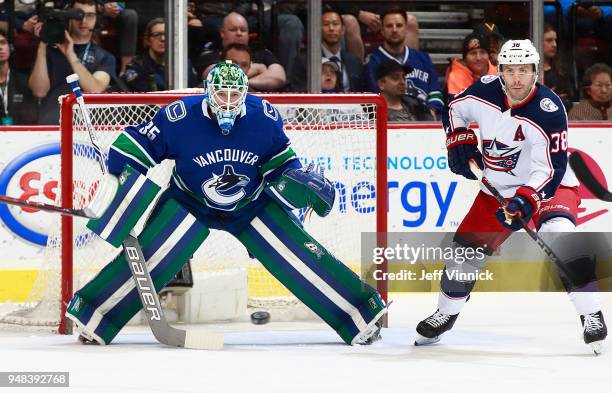 Thatcher Demko of the Vancouver Canucks and Boone Jenner of the Columbus Blue Jackets watch a shot during their NHL game at Rogers Arena March 31,...