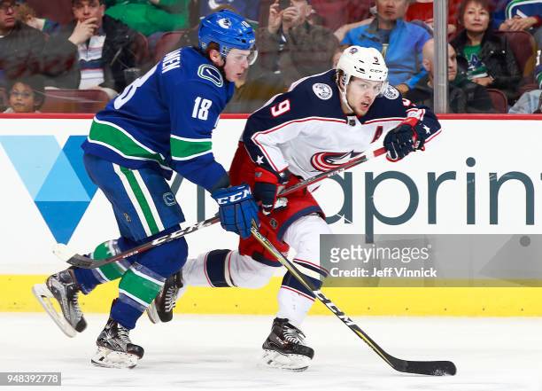 Jake Virtanen of the Vancouver Canucks checks Artemi Panarin of the Columbus Blue Jackets during their NHL game at Rogers Arena March 31, 2018 in...