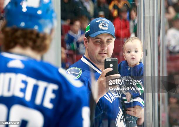 Fan takes a photo of Adam Gaudette of the Vancouver Canucks during their NHL game against the Columbus Blue Jackets at Rogers Arena March 31, 2018 in...