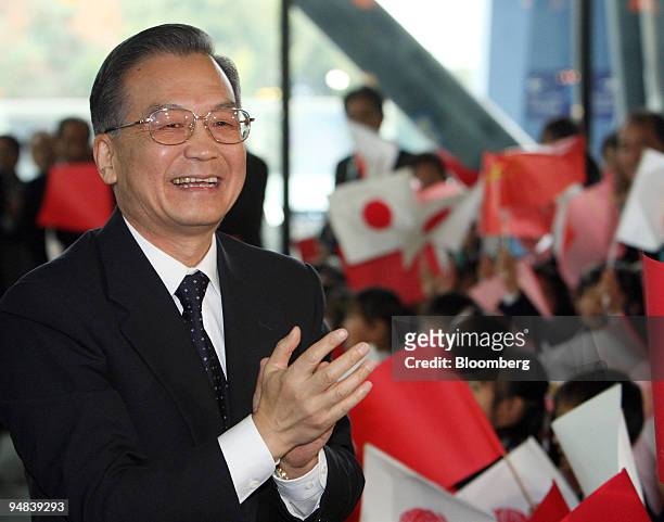 Wen Jiabao, China's premier, is welcomed by kindergartners as he arrives at the Kyushu National Museum for a meeting with Lee Myung Bak, South...