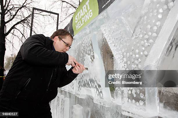 Robert Burkat carves an ice sculpture reading "Delay Kills" in an Oxfam International demonstration at the United Nations Climate Change Conference...