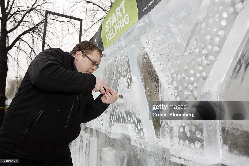 Robert Burkat carves an ice sculpture reading "Delay Kills"