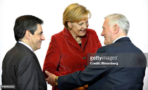 Angela Merkel, Germany's chancellor, center, speaks with Francois Fillon, France's prime minister, left, and Valdas Adamkus, Lithuainia's prime...