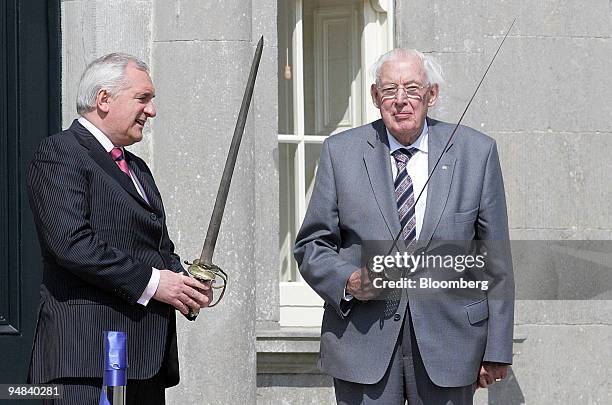 Bertie Ahern, the Irish Taoiseach, left, and Ian Paisley M.P., Northern Ireland's first minister, pose with original seventeenth century swords...