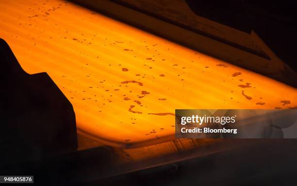 Hot steel slab moves along a conveyor of a plate mill at the Nippon Steel & Sumitomo Metal Corp. Plant in Kashima, Ibaraki, Japan, on Wednesday,...