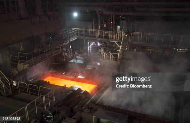 Hot steel slab moves along a conveyor of a plate mill at the Nippon Steel & Sumitomo Metal Corp. Plant in Kashima, Ibaraki, Japan, on Wednesday,...