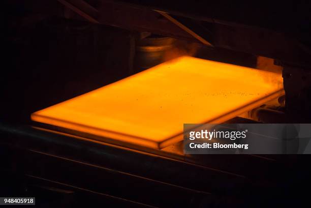 Hot steel slab moves along a conveyor of a plate mill at the Nippon Steel & Sumitomo Metal Corp. Plant in Kashima, Ibaraki, Japan, on Wednesday,...