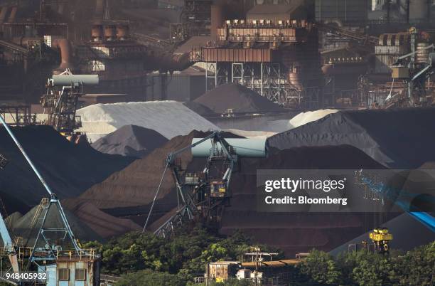 Stockpiles of raw materials including iron ore sit stacked at the Nippon Steel & Sumitomo Metal Corp. Plant in Kashima, Ibaraki, Japan, on Wednesday,...