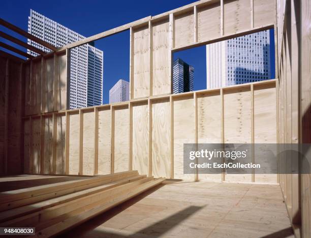 wooden skeleton at construction site in a modern city - fensterfront innen stock-fotos und bilder