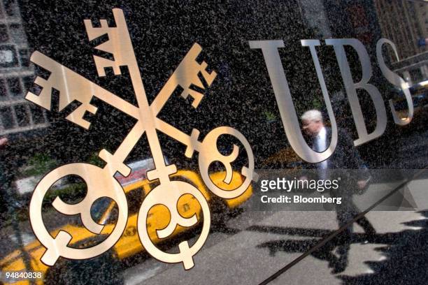 Pedestrian is reflected in a UBS logo outside the UBS offices in New York, U.S., on Monday, May 5, 2008. UBS AG, the European bank with the biggest...
