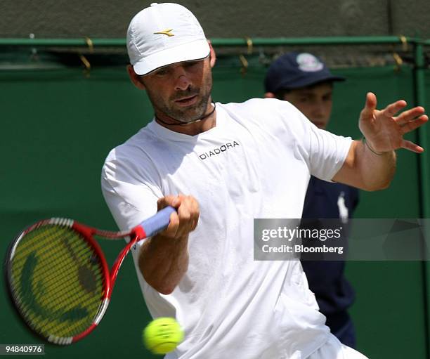 Stefano Galvani of Italy makes a return to Mikhail Youzhny of Russia, unseen, in their match at the Wimbledon tennis championships in southwest...