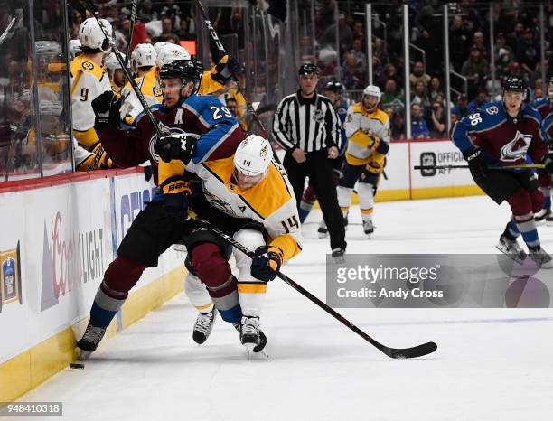 Colorado Avalanche center Nathan MacKinnon and Nashville Predators defenseman Mattias Ekholm charge after the puck along the boards in the third...