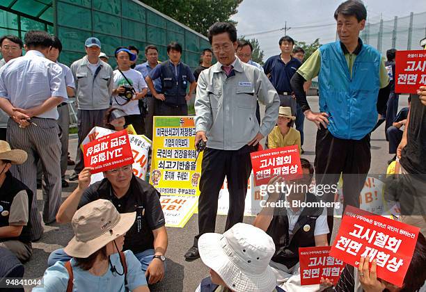 Beef storage facility employee argues with labor union members prior to the lifting of a ban against imports of U.S. Beef in Yongin, South Korea, on...