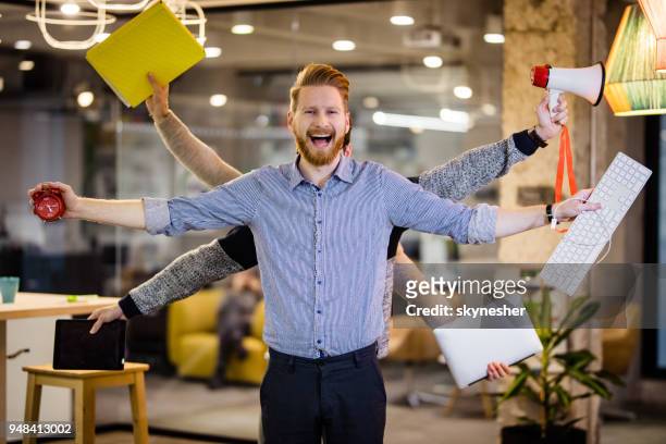 happy multi-tasking businessman with many hands in the office. - multitasking man stock pictures, royalty-free photos & images