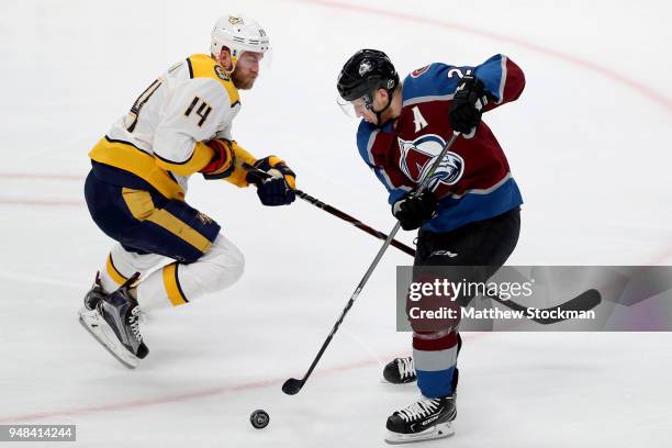 Nathan MacKinnon of the Colorado Avalanche advances the puck against Mattias Ekholm of the Nashville Predators in Game Four of the Western Conference...