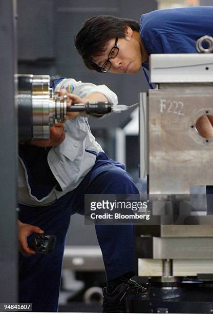 Employees work on the production line manufacturing construction equipment at the Doosan Infracore plant in Changwon, South Korea, on Friday, Sept....