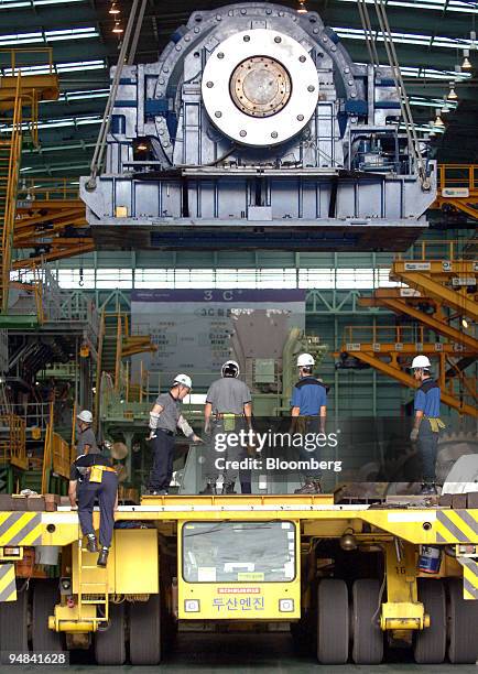 Employees work on the production line manufacturing ship engines at Doosan Engine Co.'s plant in Changwon, South Korea, on Friday, Sept. 26, 2008....